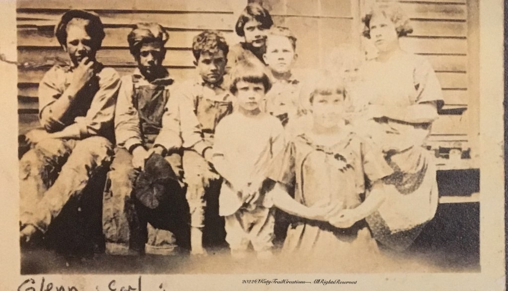 Glenn was known to wear overalls and a hat much of the time. Apparently this goes way back to childhood. He is the first one on the left with Earl sitting beside him.